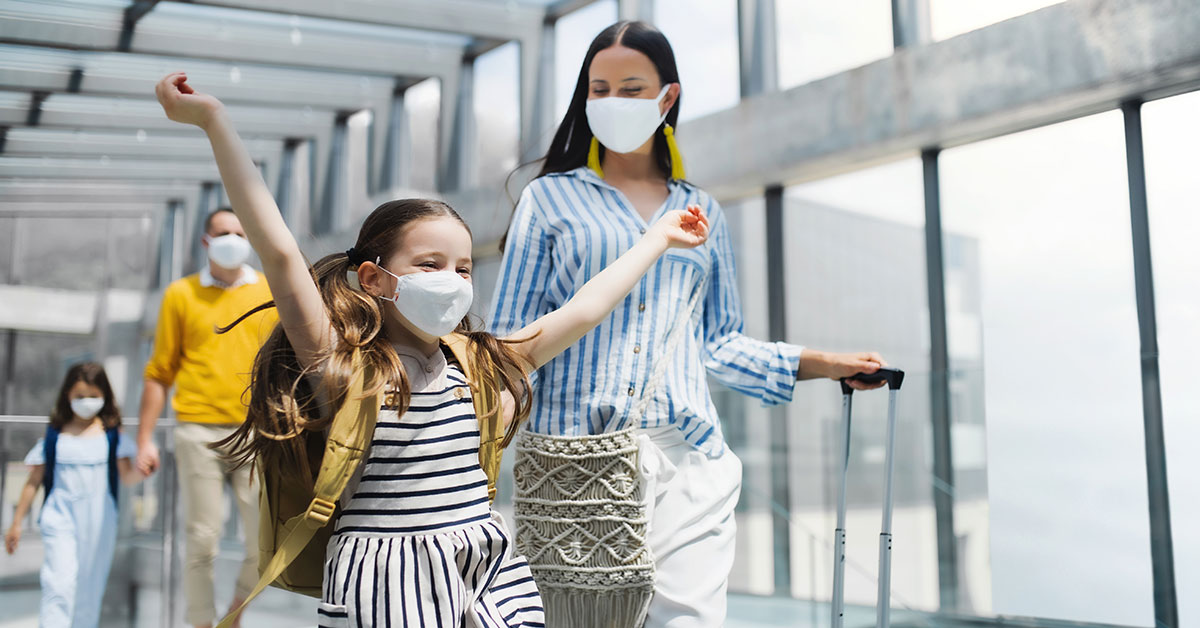 A family walking through the airport with masks on