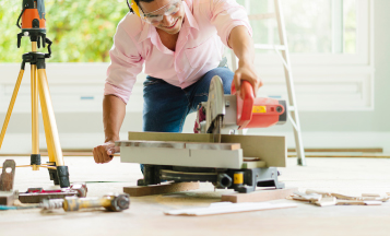 a couple staining hardwood floors in their home